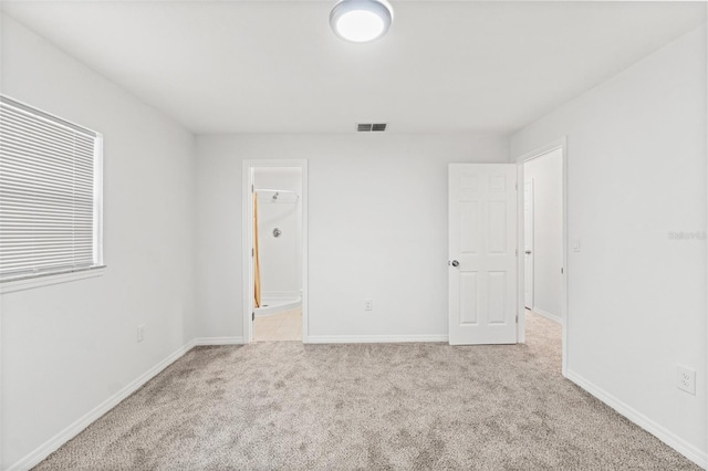 carpeted spare room featuring baseboards and visible vents