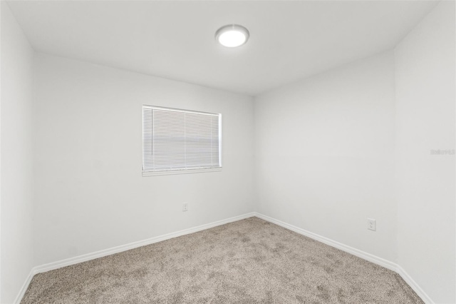 carpeted spare room with baseboards