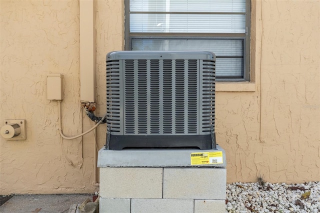 exterior details with central AC unit and stucco siding