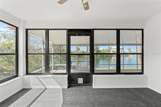 spare room with carpet flooring, a water view, baseboards, and ceiling fan