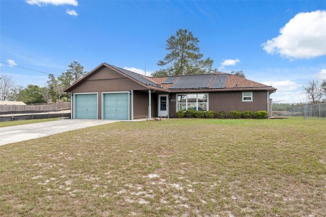 ranch-style home with a front yard, roof mounted solar panels, fence, and driveway