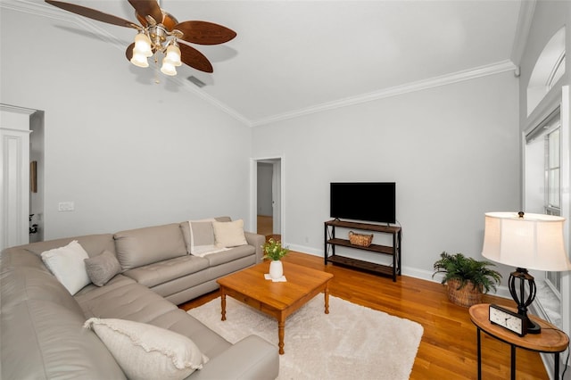 living area with lofted ceiling, wood finished floors, visible vents, baseboards, and ornamental molding