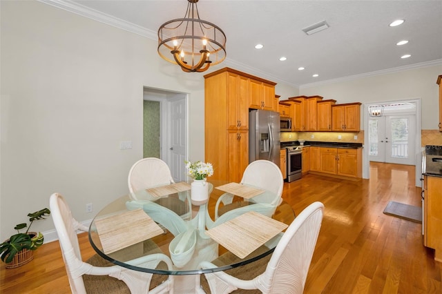 dining space featuring recessed lighting, a notable chandelier, visible vents, light wood-type flooring, and crown molding