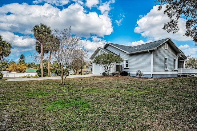 view of side of home featuring a garage, a yard, and driveway