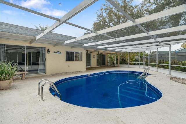 outdoor pool with glass enclosure and a patio