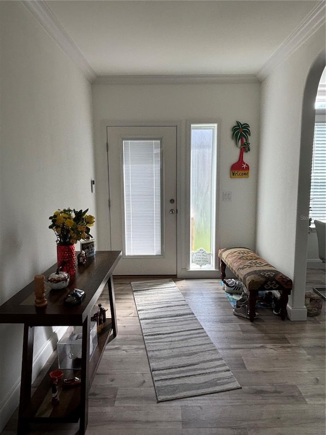 doorway featuring ornamental molding and light hardwood / wood-style flooring