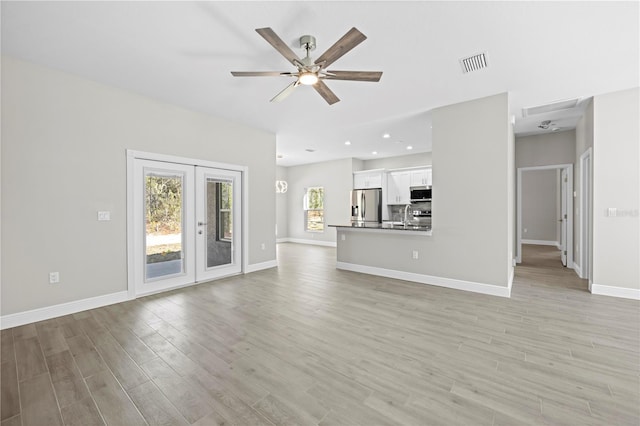 unfurnished living room featuring french doors, ceiling fan, light hardwood / wood-style floors, and sink