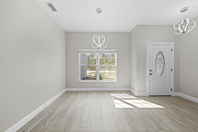 11345 Thrasher Ave, Weeki Wachee, FL 34614 - entrance foyer featuring a chandelier, light wood-style flooring, and baseboards