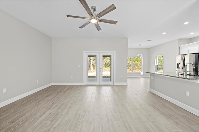 11345 Thrasher Ave, Weeki Wachee, FL 34614 - unfurnished living room with light wood-style floors, baseboards, recessed lighting, ceiling fan, and french doors
