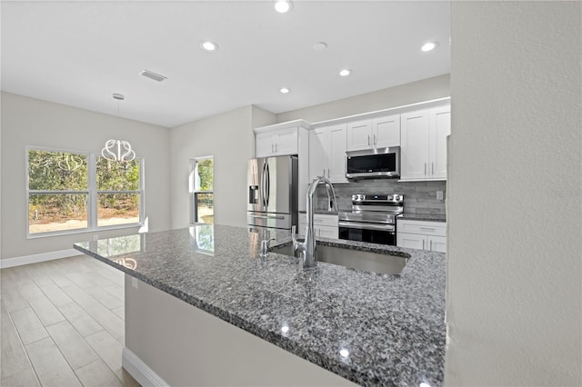 11345 Thrasher Ave, Weeki Wachee, FL 34614 - kitchen featuring stainless steel appliances, white cabinets, tasteful backsplash, a sink, and recessed lighting