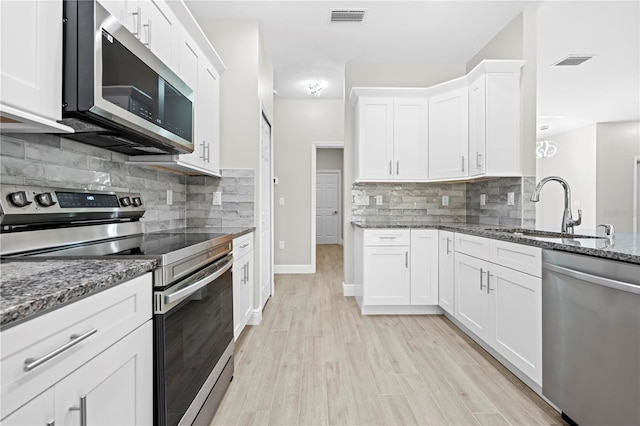 11345 Thrasher Ave, Weeki Wachee, FL 34614 - kitchen featuring appliances with stainless steel finishes, a sink, tasteful backsplash, and stone counters