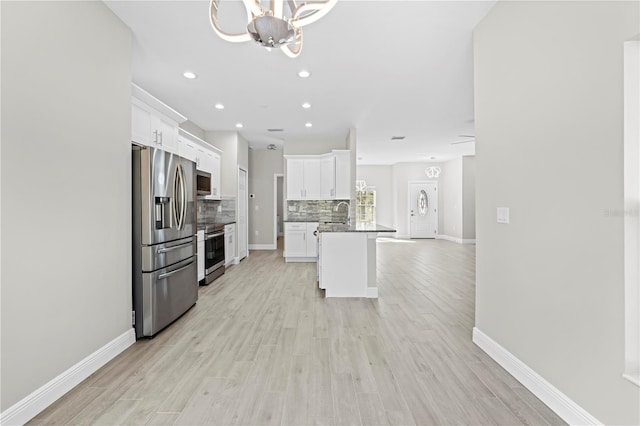 11345 Thrasher Ave, Weeki Wachee, FL 34614 - kitchen featuring appliances with stainless steel finishes, decorative backsplash, white cabinetry, open floor plan, and recessed lighting