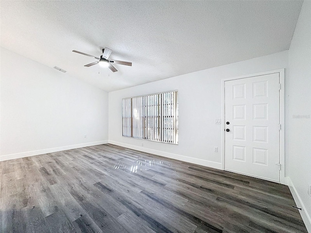 spare room featuring a textured ceiling, dark wood-type flooring, vaulted ceiling, and ceiling fan