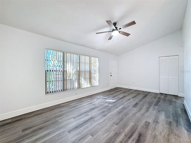 unfurnished room with ceiling fan, vaulted ceiling, wood-type flooring, and a textured ceiling