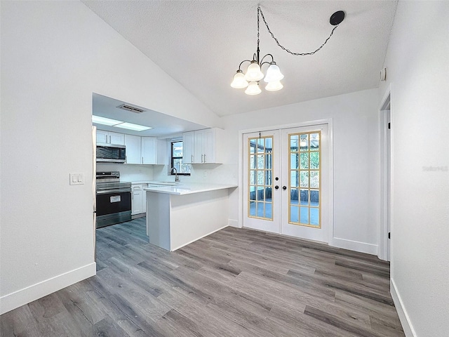 kitchen featuring kitchen peninsula, french doors, sink, appliances with stainless steel finishes, and white cabinets