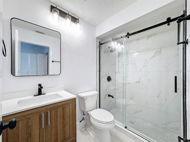 bathroom featuring toilet, vanity, an enclosed shower, and a textured ceiling