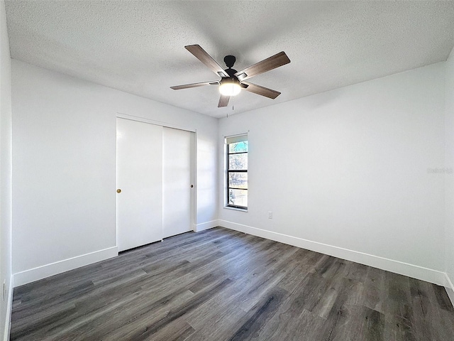 unfurnished bedroom featuring a textured ceiling, a closet, ceiling fan, and dark hardwood / wood-style flooring