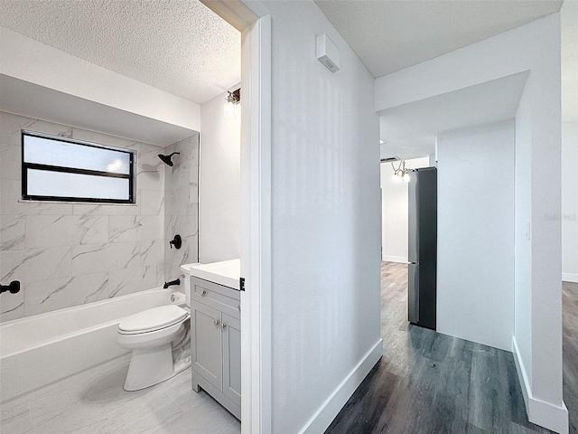 full bathroom featuring toilet, tiled shower / bath, a textured ceiling, vanity, and hardwood / wood-style floors