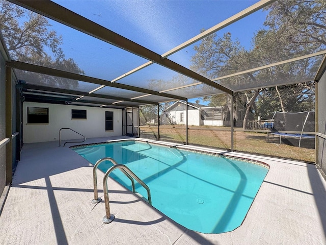 view of swimming pool featuring a patio and glass enclosure