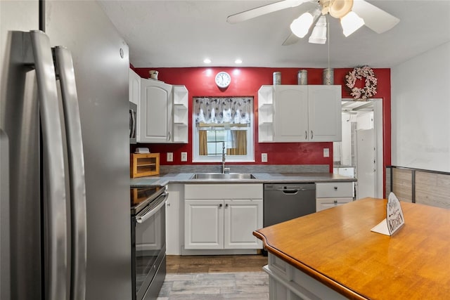 kitchen with white cabinets, appliances with stainless steel finishes, open shelves, and a sink