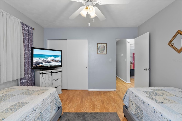 bedroom with ceiling fan, a closet, light wood-type flooring, and baseboards