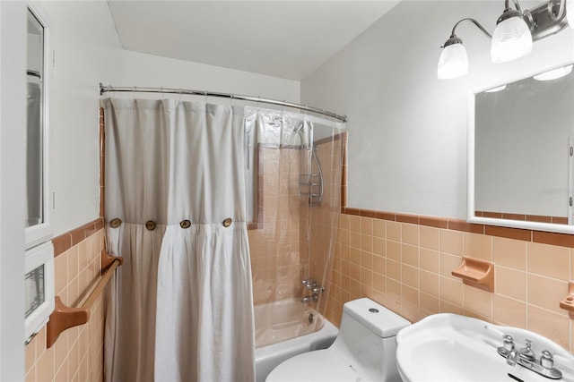 bathroom featuring shower / bath combination with curtain, a sink, tile walls, and toilet