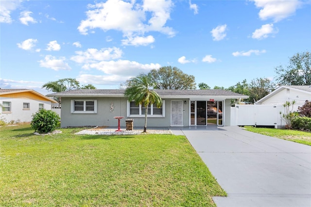 ranch-style house with a gate, driveway, a front lawn, and stucco siding