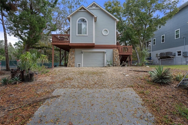 view of front of home featuring a garage, driveway, a deck, and fence