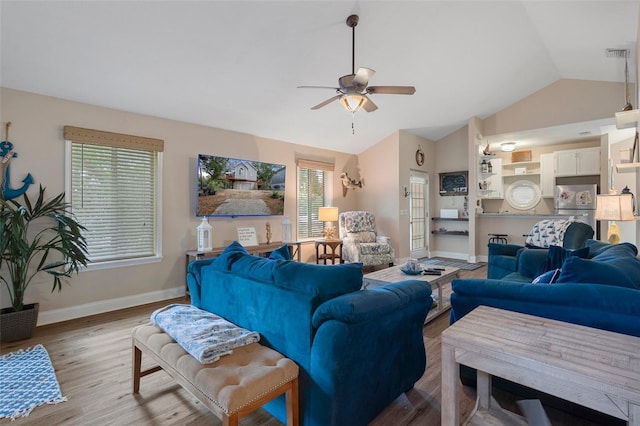 living area with ceiling fan, light wood-style flooring, visible vents, baseboards, and vaulted ceiling