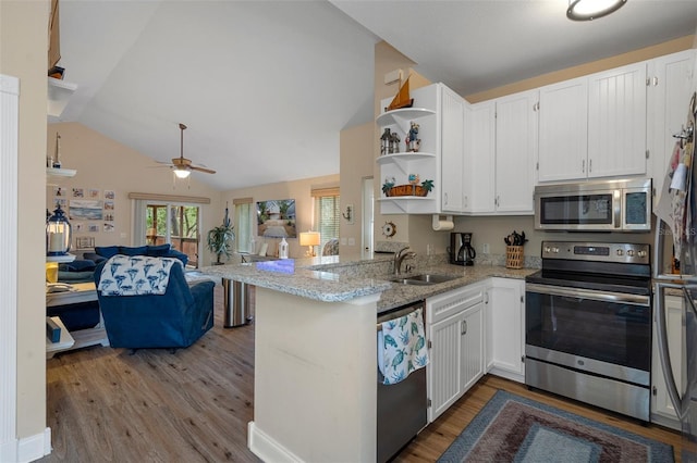 kitchen featuring a peninsula, white cabinetry, stainless steel appliances, and a sink