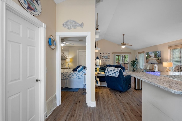 interior space featuring vaulted ceiling, wood finished floors, and visible vents