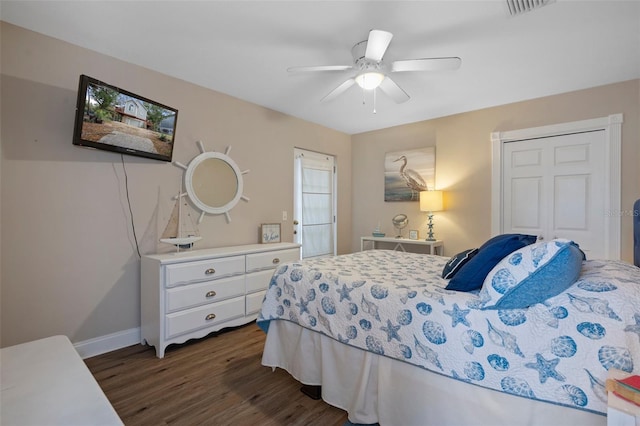 bedroom with dark wood-style floors, ceiling fan, visible vents, and baseboards