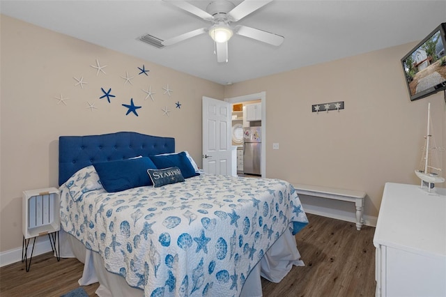 bedroom with freestanding refrigerator, visible vents, baseboards, and wood finished floors