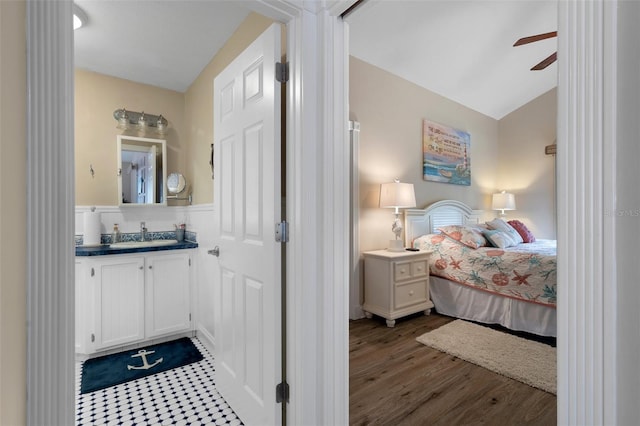 bedroom featuring vaulted ceiling, a ceiling fan, dark wood finished floors, and a sink