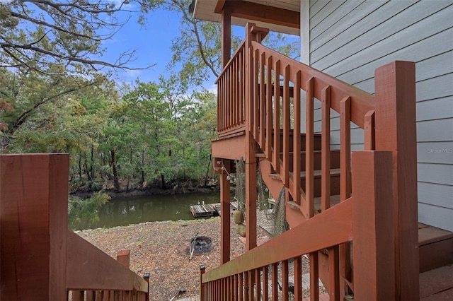 wooden terrace featuring a water view and stairway