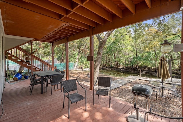 wooden terrace with stairs, grilling area, and outdoor dining space