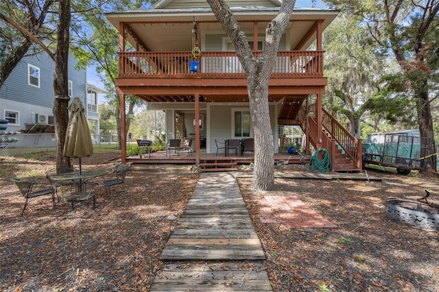 rear view of property with a deck and stairway