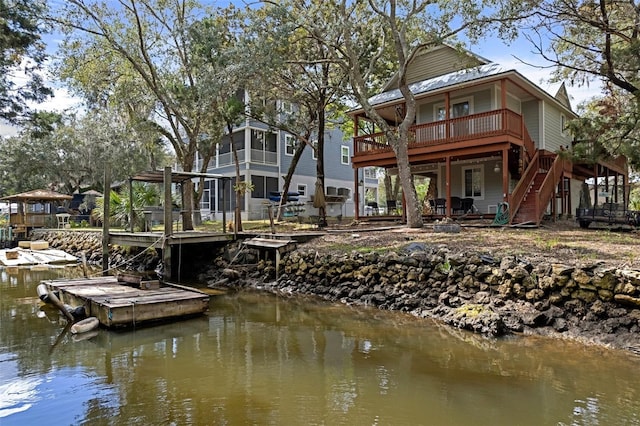 back of house featuring a deck with water view and stairs