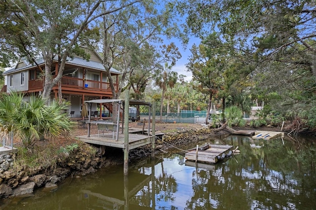 view of dock with a water view and fence