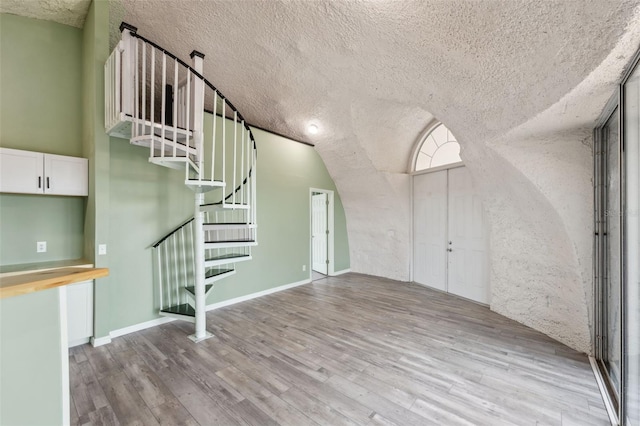 interior space featuring light wood-type flooring and a textured ceiling