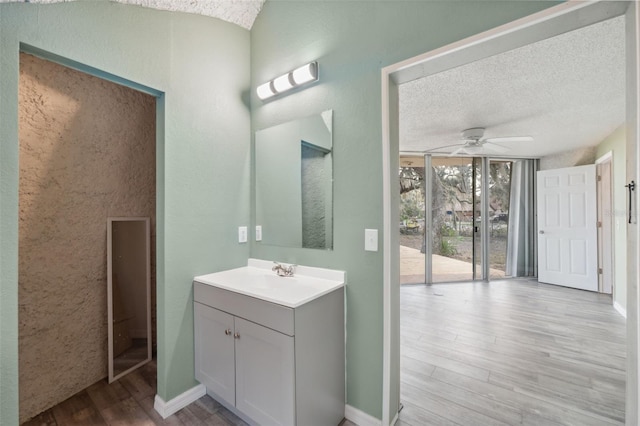 bathroom featuring hardwood / wood-style flooring, a textured ceiling, ceiling fan, floor to ceiling windows, and vanity