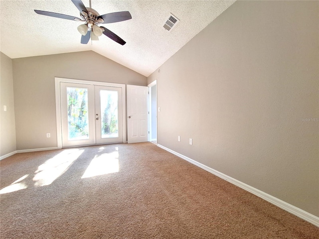 empty room featuring lofted ceiling, french doors, carpet, and visible vents