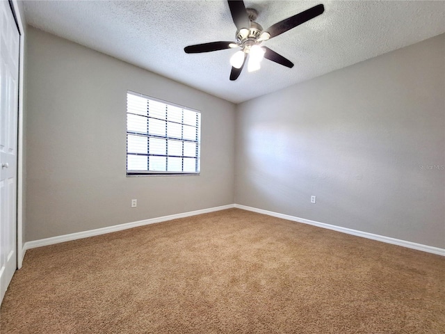 unfurnished room featuring a textured ceiling, ceiling fan, carpet, and baseboards