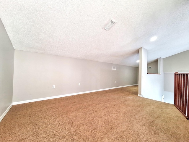 bonus room featuring carpet floors, visible vents, vaulted ceiling, and a textured ceiling