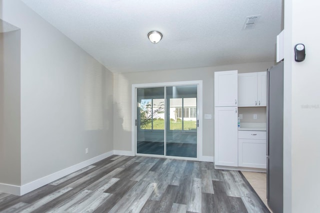 interior space featuring visible vents, baseboards, and wood finished floors