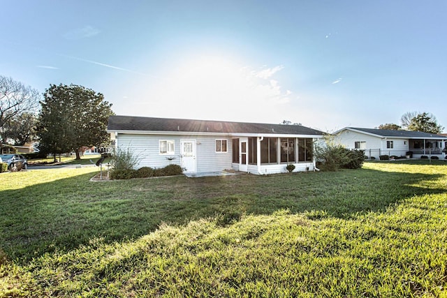 view of front of property featuring a front yard, fence, and a sunroom