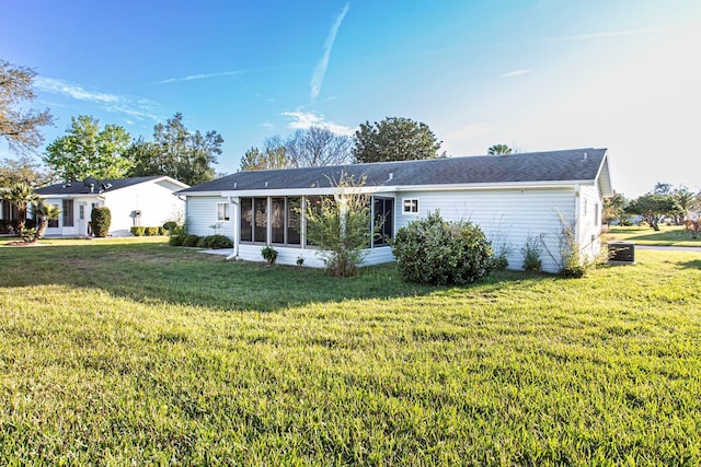 back of property featuring a sunroom and a yard