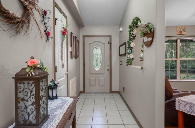 foyer with light tile patterned floors and a textured ceiling