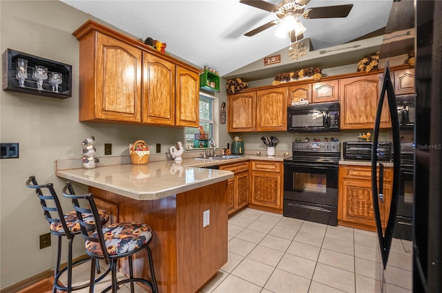 kitchen with vaulted ceiling, sink, a breakfast bar, black appliances, and kitchen peninsula