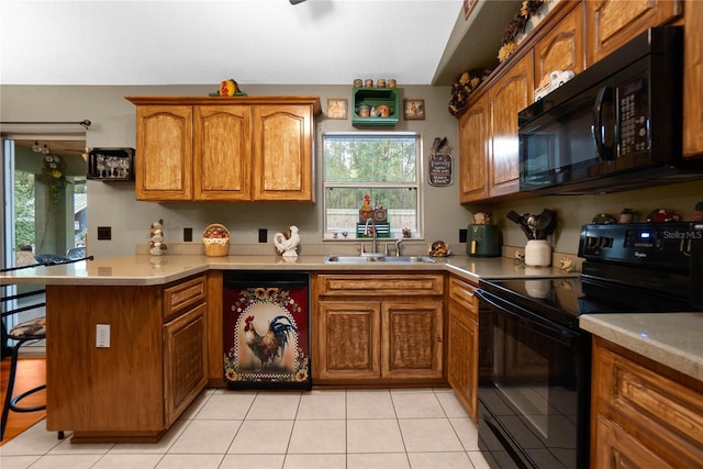 kitchen featuring a breakfast bar area, black appliances, light tile patterned floors, sink, and kitchen peninsula